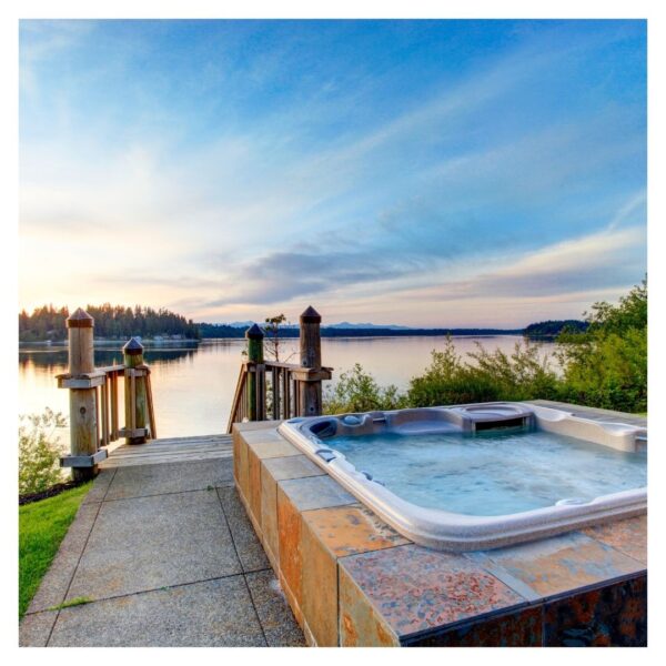 Hot tub by lake, scenic sunset view