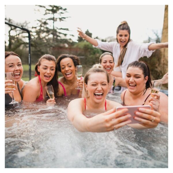 Group taking selfie in hot tub, laughing