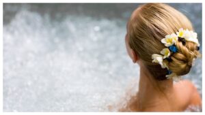 Woman in hot tub, flower-adorned hair