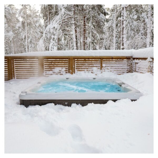 Outdoor hot tub surrounded by snow-covered forest