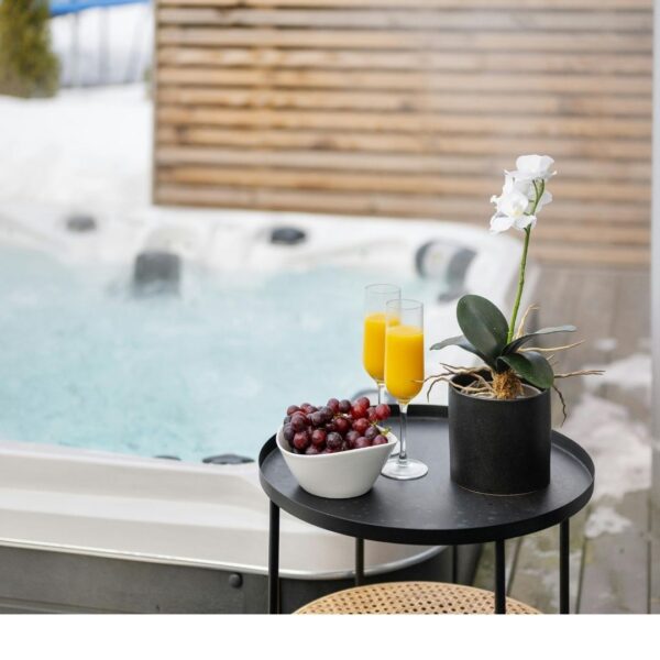 mimosas in champagne glasses and grapes on table by hot tub