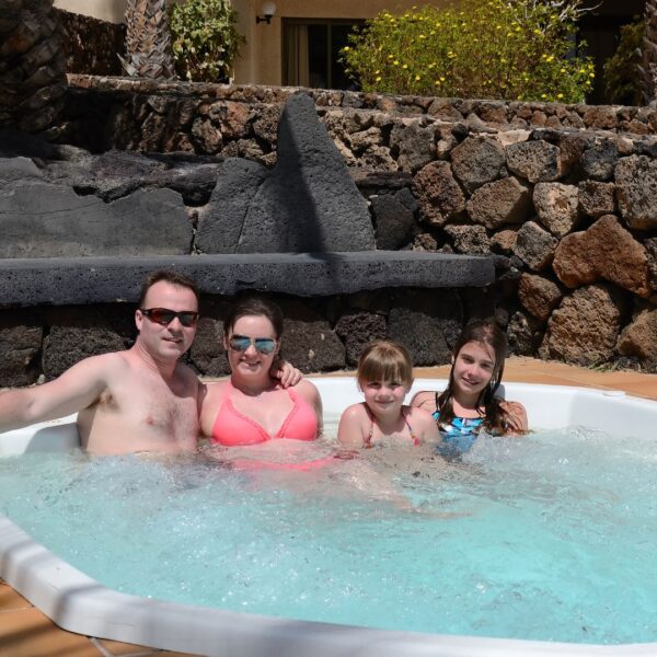 family sits on one side of hot tub 
